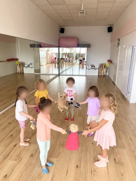 Kinder stehen im Kreis und halten Kuscheltiere