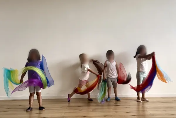 Kinder tanzen mit bunten Tüchern