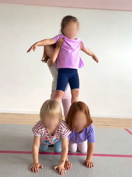 Drei Kinder bauen eine Pyramide auf der Matte
