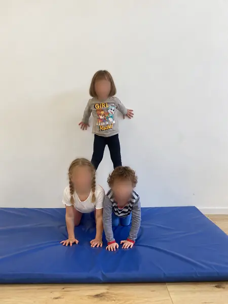 Kinderpyramide auf der blauen Turnmatte