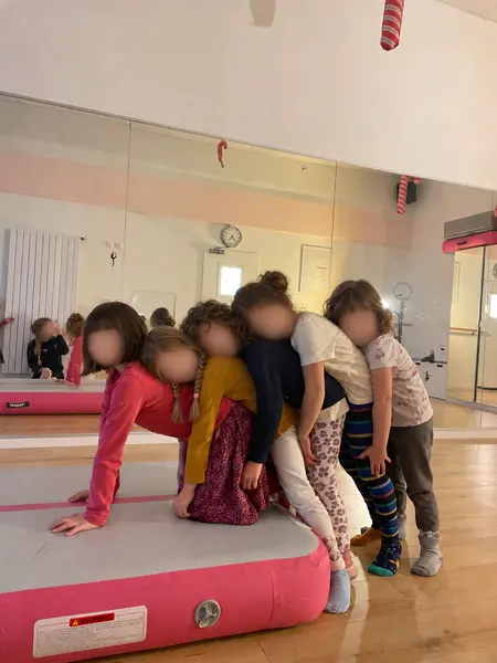 Kinder kuscheln sich auf der Airtrack-Matte aneinander